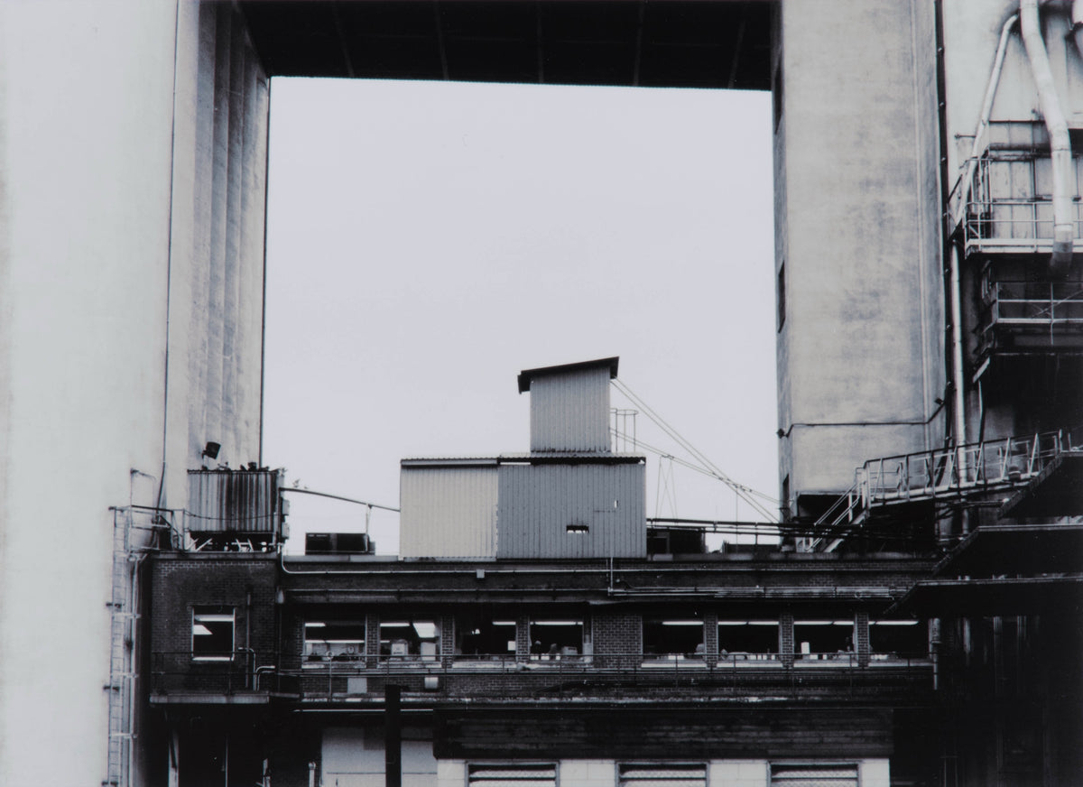 Wayne Eastcott, Moodyville Notes 6, 2005. Photograph of a building and its rooftop, being framed by a larger building on top.