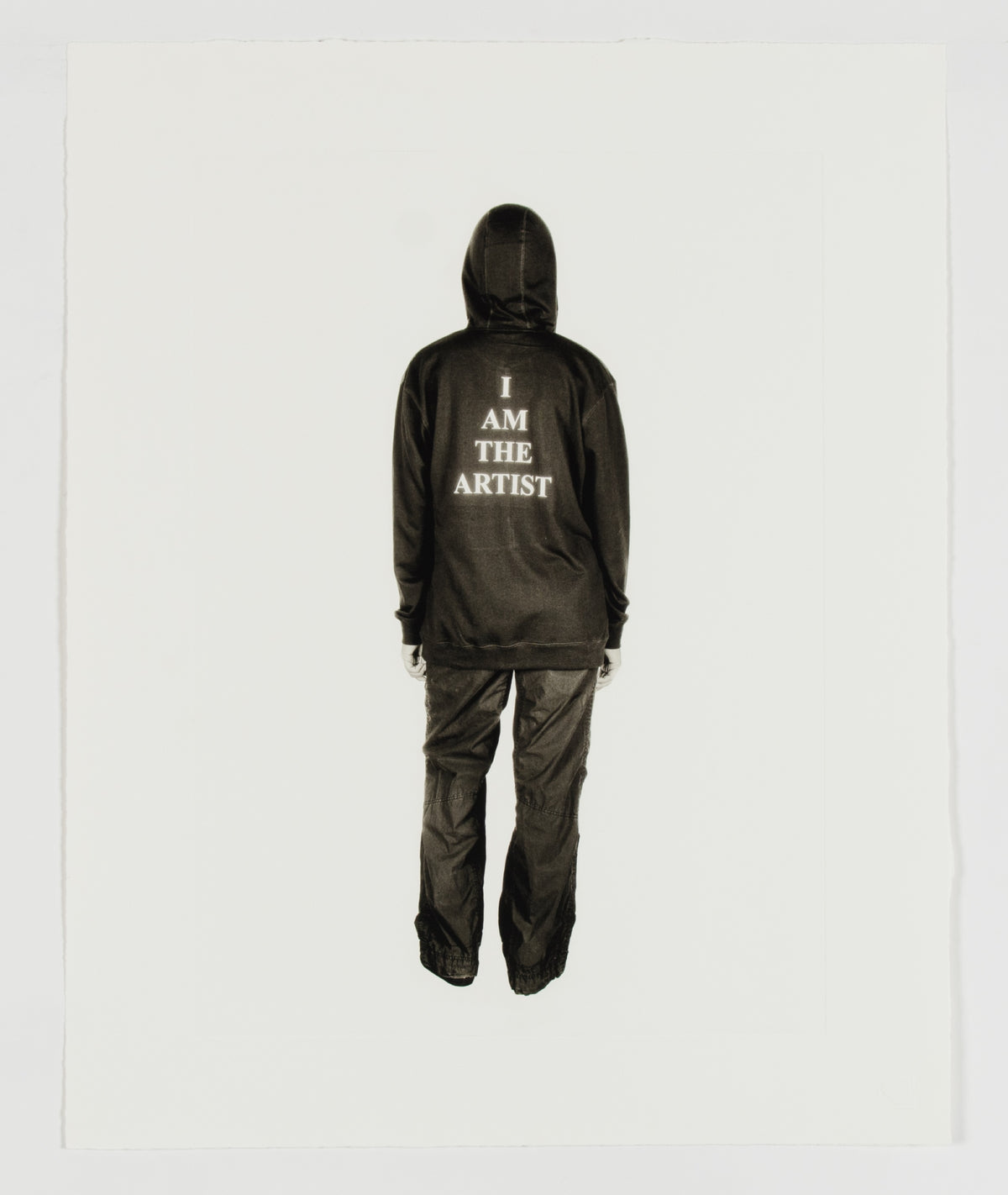 Rebecca Belmore, I am the Artist, 2021. Image of the back of a person wearing jeans and hoodie. The back of the hoodie says "I am the Artist".