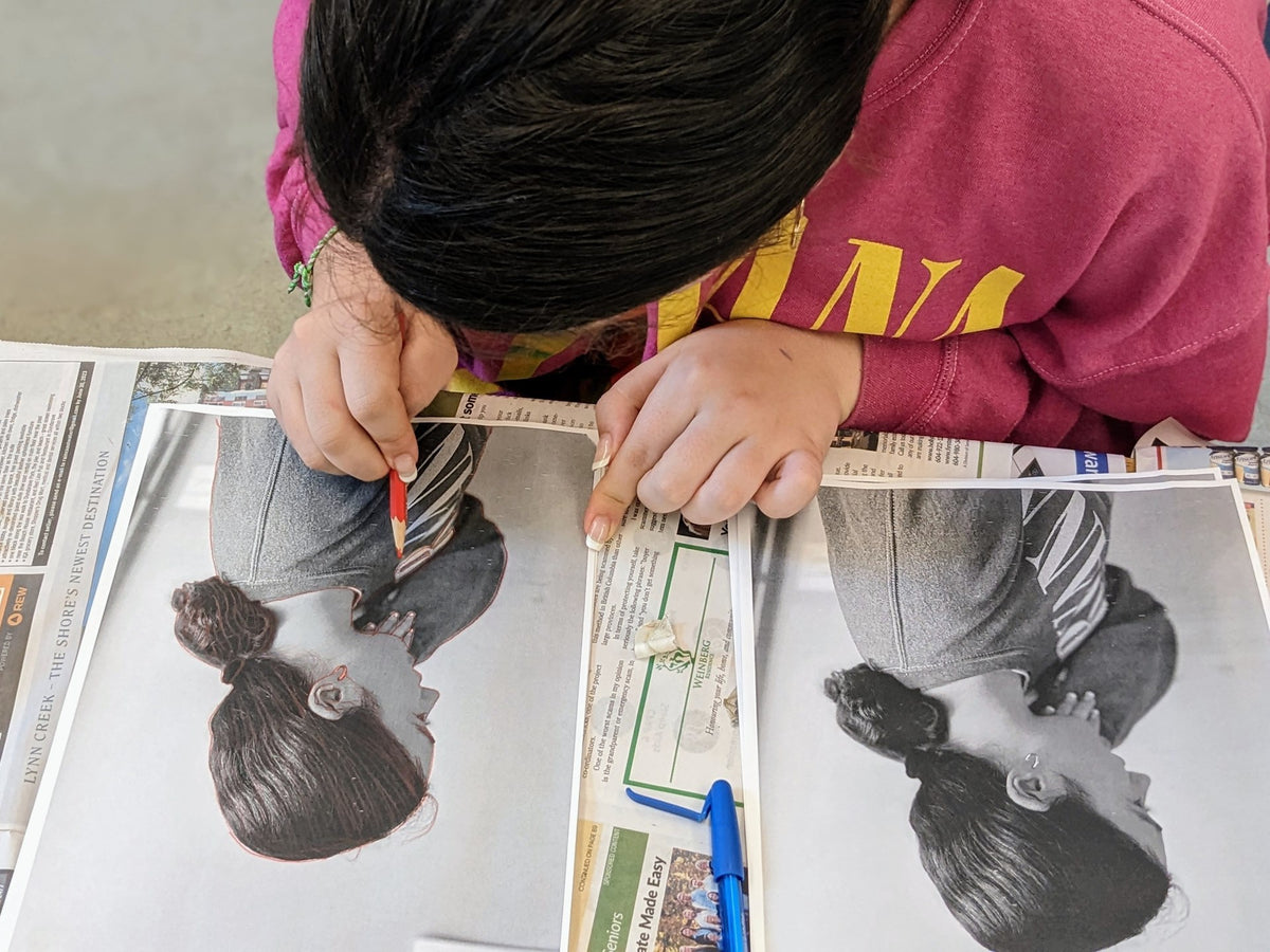 A student tracing over a printed self portrait photo to make a monotype