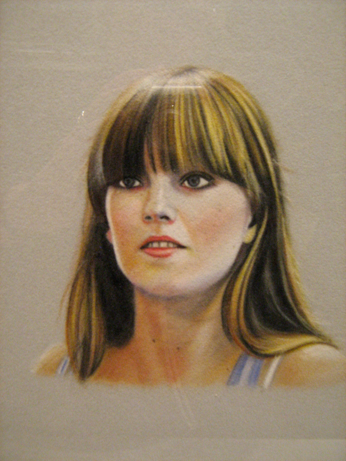 Karin Bubaš, Kimberley, 2009. This is a drawing on grey paper where the head and neck of a woman are small and centered. It is a drawing in chalk pastel of a dirty blond woman wearing makeup with bangs.